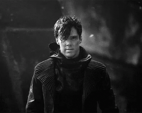 A Black And White Photo Of A Man In A Black Coat GIF