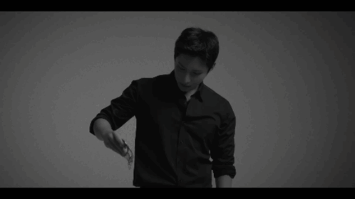 A Black And White Photo Of A Man In A Black Shirt And Black Pants . GIF