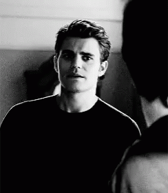 A Black And White Photo Of A Man In A Black Shirt Talking To Another Man GIF