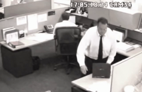 A Black And White Photo Of A Man In A Cubicle With Cam34 Written On The Bottom Right GIF