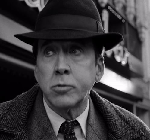 A Black And White Photo Of A Man In A Hat GIF