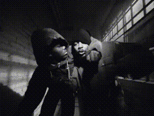 A Black And White Photo Of A Man In A Hoodie Smoking A Cigarette GIF