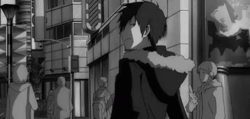 A Black And White Photo Of A Man In A Hoodie Walking Down A Street . GIF