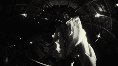 A Black And White Photo Of A Man In A Lab Coat With A Name Tag That Says ' A.j. ' On It GIF