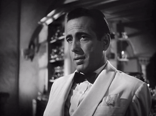 a black and white photo of a man in a suit and bow tie