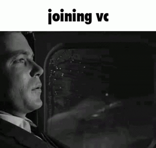 A Black And White Photo Of A Man In A Suit And Tie Looking Out A Window . GIF