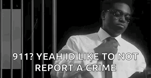 A Black And White Photo Of A Man In A Suit And Tie Standing In Front Of A Jail Cell . GIF