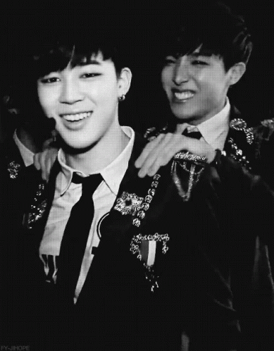 A Black And White Photo Of A Man In A Suit And Tie With His Arm Around Another Man 'S Shoulder GIF
