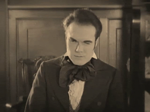 A Black And White Photo Of A Man In A Suit GIF