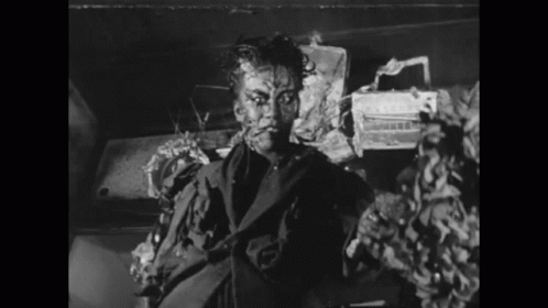 A Black And White Photo Of A Man In A Suit With His Face Painted GIF