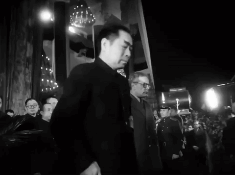 A Black And White Photo Of A Man In A Suit GIF