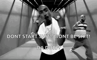 a black and white photo of a man in a white shirt dancing in a hallway .