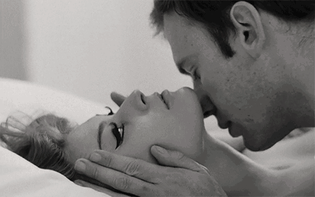 A Black And White Photo Of A Man Kissing A Woman On The Forehead . GIF