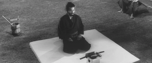 A Black And White Photo Of A Man Kneeling On A Mattress GIF