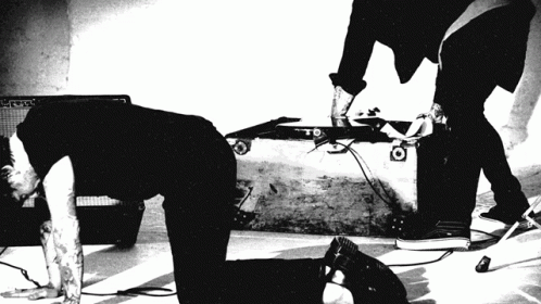 A Black And White Photo Of A Man Kneeling On The Floor GIF