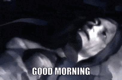 a black and white photo of a man laying down with the words good morning written below him .