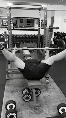 A Black And White Photo Of A Man Lifting Weights GIF