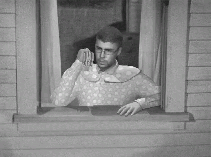 A Black And White Photo Of A Man Looking Out Of A Window With A Dollar Bill In His Hand GIF