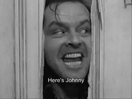 A Black And White Photo Of A Man Looking Through A Door With The Words `` Here 'S Johnny '' Written Below Him . GIF