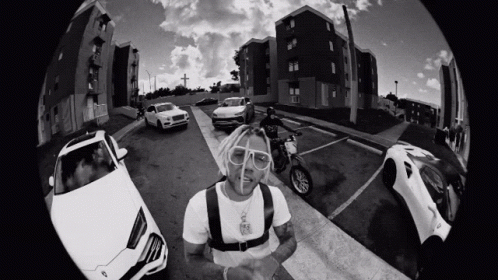 A Black And White Photo Of A Man On A Motorcycle Surrounded By Cars GIF