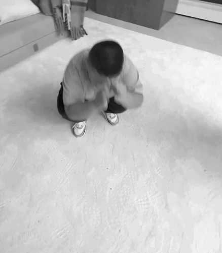 A Black And White Photo Of A Man On His Knees GIF