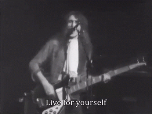 A Black And White Photo Of A Man Playing A Guitar And Singing Into A Microphone With The Words Live For Yourself . GIF