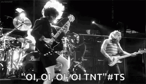A Black And White Photo Of A Man Playing A Guitar In Front Of A Drum Set . GIF