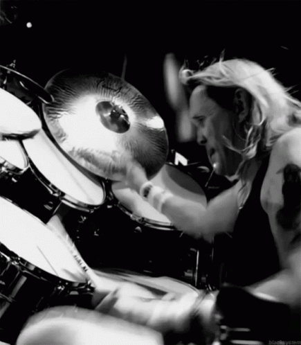 A Black And White Photo Of A Man Playing Drums GIF
