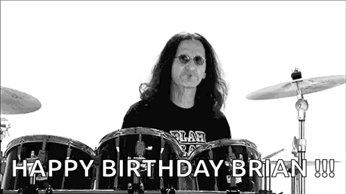 A Black And White Photo Of A Man Playing Drums With The Words `` Happy Birthday Brian '' Behind Him . GIF