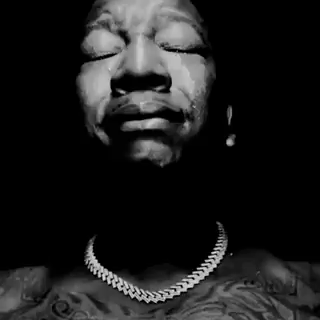 A Black And White Photo Of A Man Praying With His Hands Folded In Front Of His Face . GIF