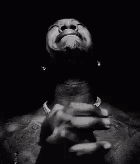 a black and white photo of a man praying with his hands folded in prayer .