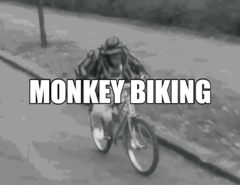 A Black And White Photo Of A Man Riding A Bicycle With The Words Monkey Biking Written Above Him GIF