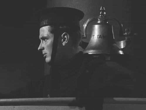 a black and white photo of a man ringing a bell that says titanic