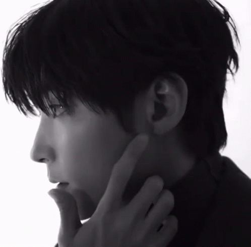 A Black And White Photo Of A Man 'S Face With His Hand On His Chin GIF