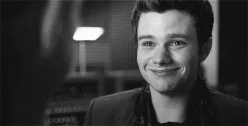A Black And White Photo Of A Man Smiling In A Room . GIF