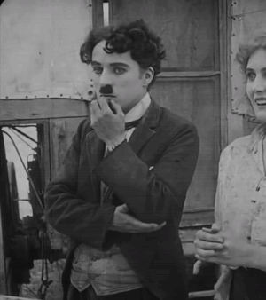 A Black And White Photo Of A Man Smoking A Cigarette And A Woman Smiling GIF