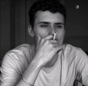 A Black And White Photo Of A Man Smoking A Cigarette With The Letter B On The Bottom Right GIF