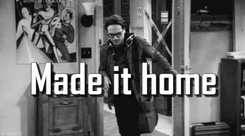 A Black And White Photo Of A Man Standing In A Hallway With The Words `` Made It Home '' Written On It . GIF