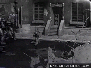 A Black And White Photo Of A Man Standing In Front Of A Building With The Words Make Gifs At Gifsoup.com Below It GIF