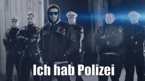 A Black And White Photo Of A Man Standing In Front Of A Group Of Police Officers With Ich Hab Polizei Written On The Bot GIF