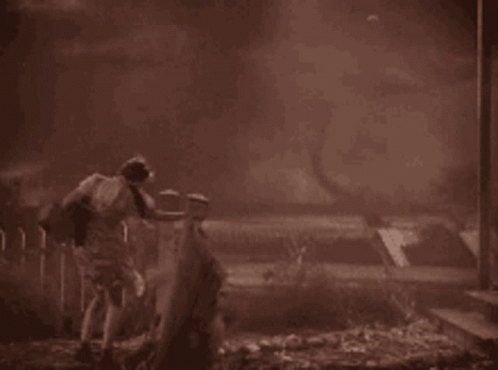 A Black And White Photo Of A Man Standing In The Dark GIF