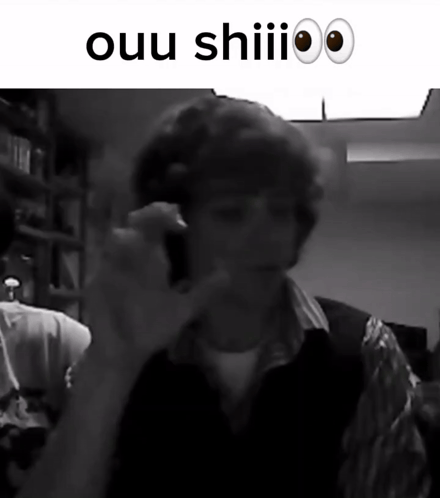 A Black And White Photo Of A Man Talking On A Cell Phone With The Words Ouu Shiii Above Him GIF