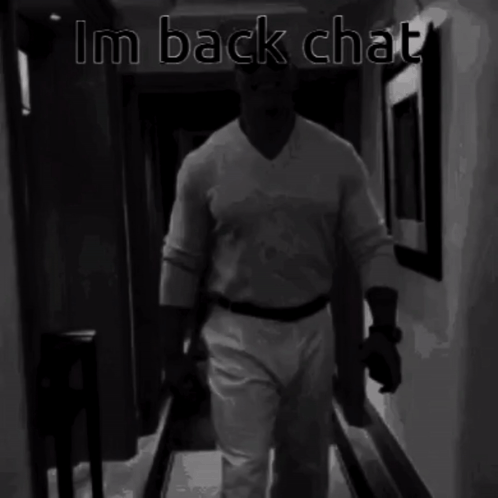 A Black And White Photo Of A Man Walking Down A Hallway With The Words Im Back Chat Above Him GIF