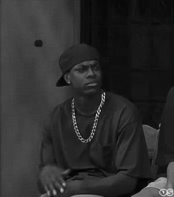 A Black And White Photo Of A Man Wearing A Bandana And A Necklace . GIF