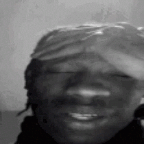 A Black And White Photo Of A Man Wearing A Bandana On His Head . GIF