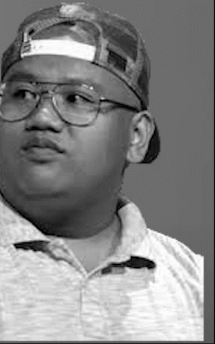 A Black And White Photo Of A Man Wearing A Baseball Cap And Glasses . GIF