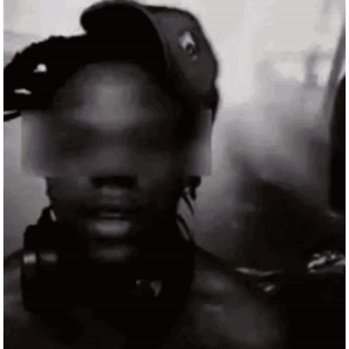 A Black And White Photo Of A Man Wearing A Baseball Cap And Headphones . GIF