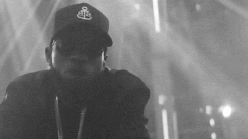 A Black And White Photo Of A Man Wearing A Baseball Cap GIF