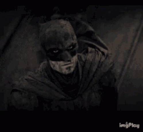 A Black And White Photo Of A Man Wearing A Batman Mask . GIF