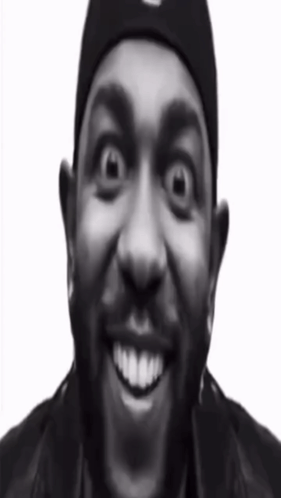 A Black And White Photo Of A Man Wearing A Beanie And Smiling GIF
